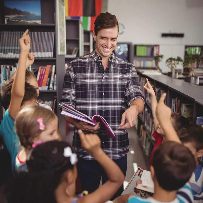 Male teacher in library with students